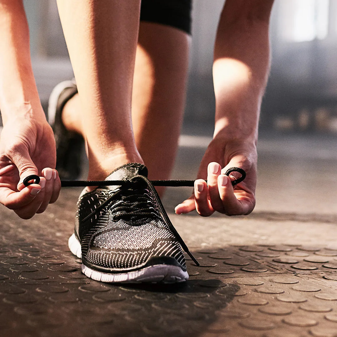 close up of woman tying sports trainers