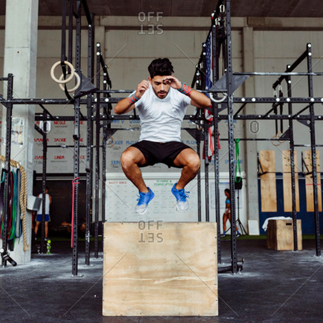 Man working out on plyo box on gym flooring